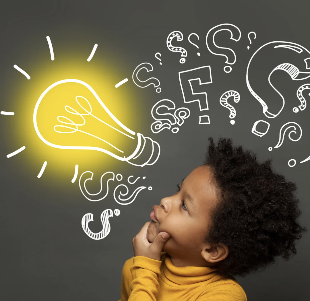 Little boy in yellow shirt looking up at light bulb.