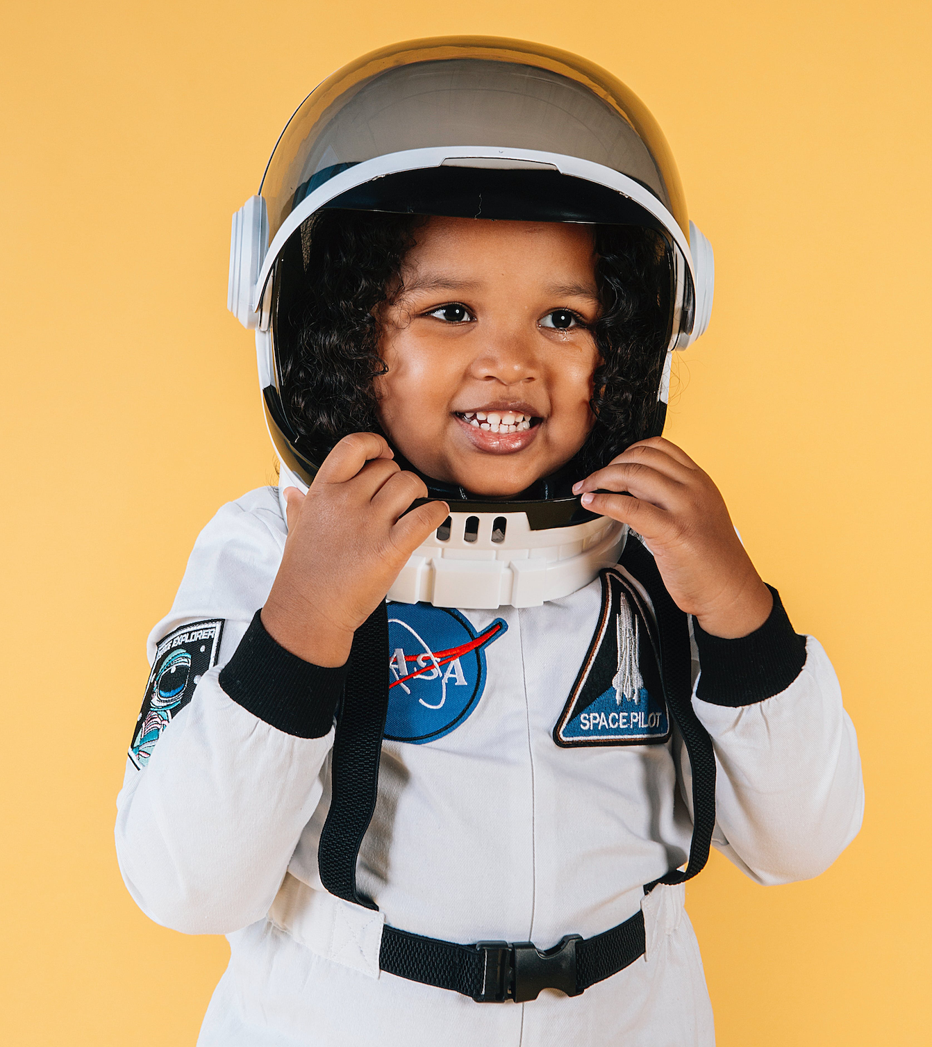 Little girl in an astronaut soot smiling.